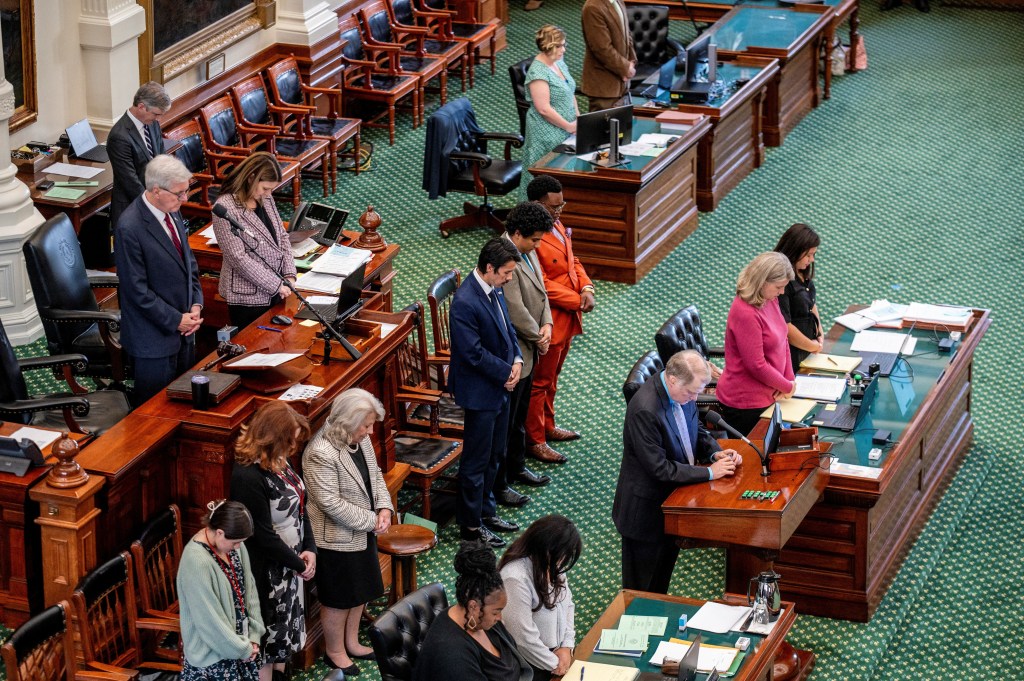 Texas lawmakers bow their heads in prayer before the voting session on Aug. 22, 2025.