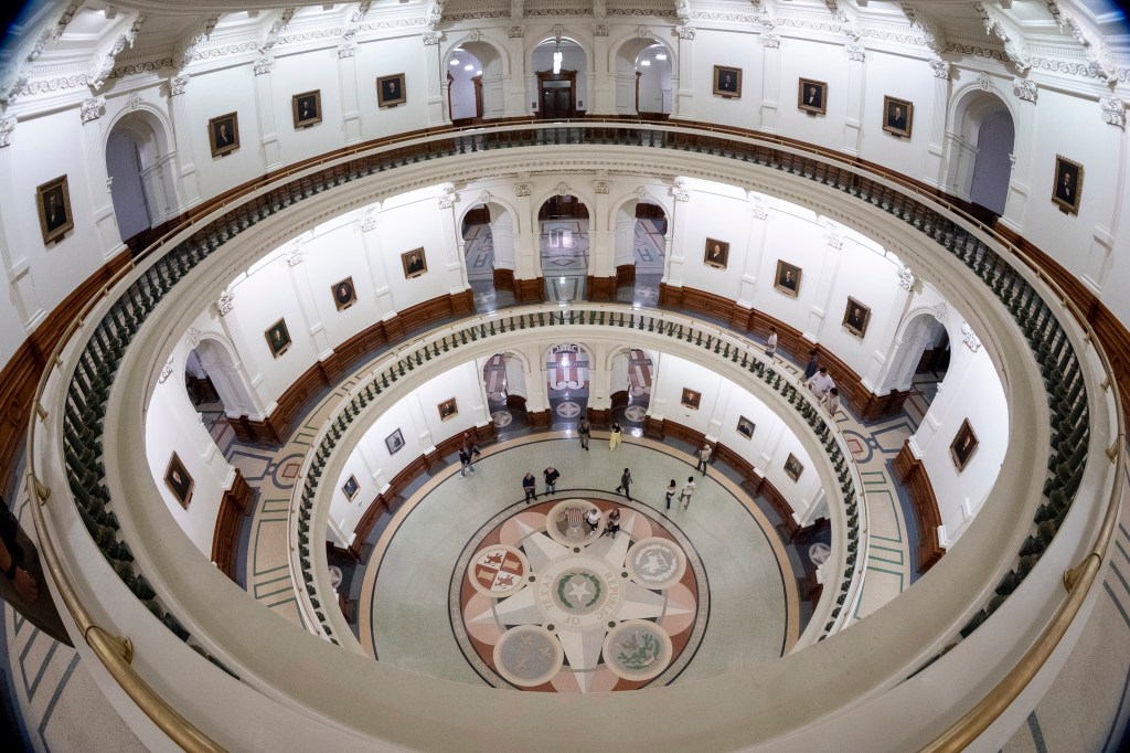 Visitors walk in the rotunda of the Texas Capitol during the state senate's late night bill vote.
