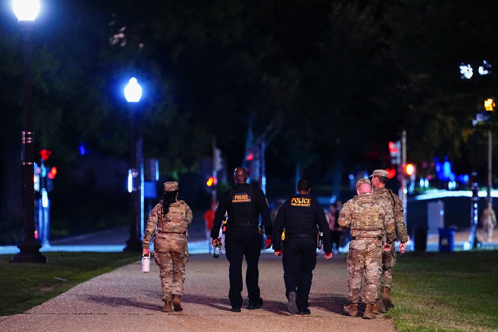 Members of the National Guard and Homeland Security agents walk around the National Mall after being deployed to the city to combat crime and illegal immigration.