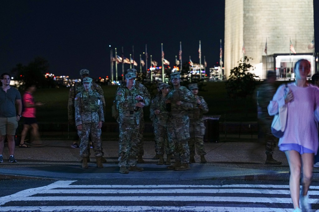 National Guard members stand guard on the National Mall near the Washington Monument on Aug. 22, 2025.