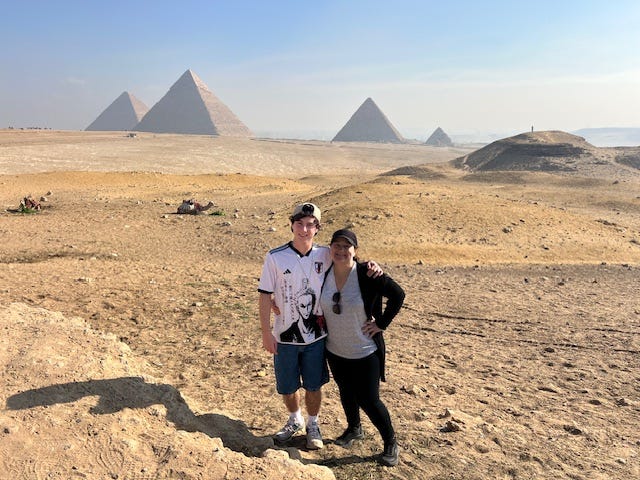 mother and son in egypt with pyramids in the background