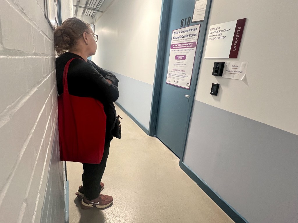 Woman waiting outside Alexandria Ocasio-Cortez's Bronx office.