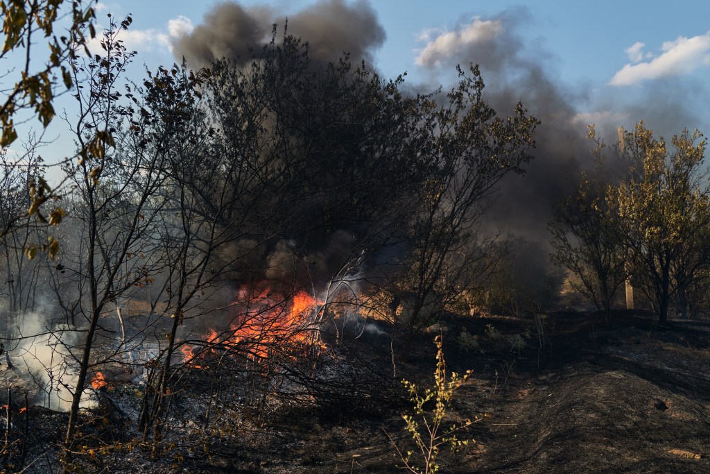 Fire burning in vegetation and trees following a drone strike in Kramatorsk, Ukraine.