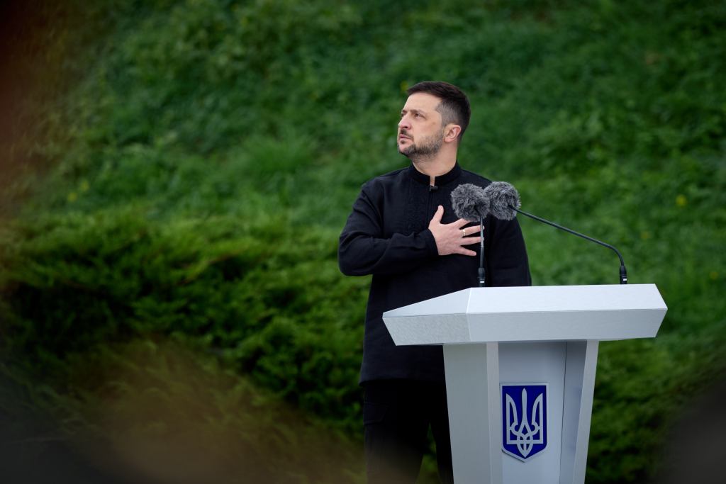Volodymyr Zelenskyy speaking at a podium.