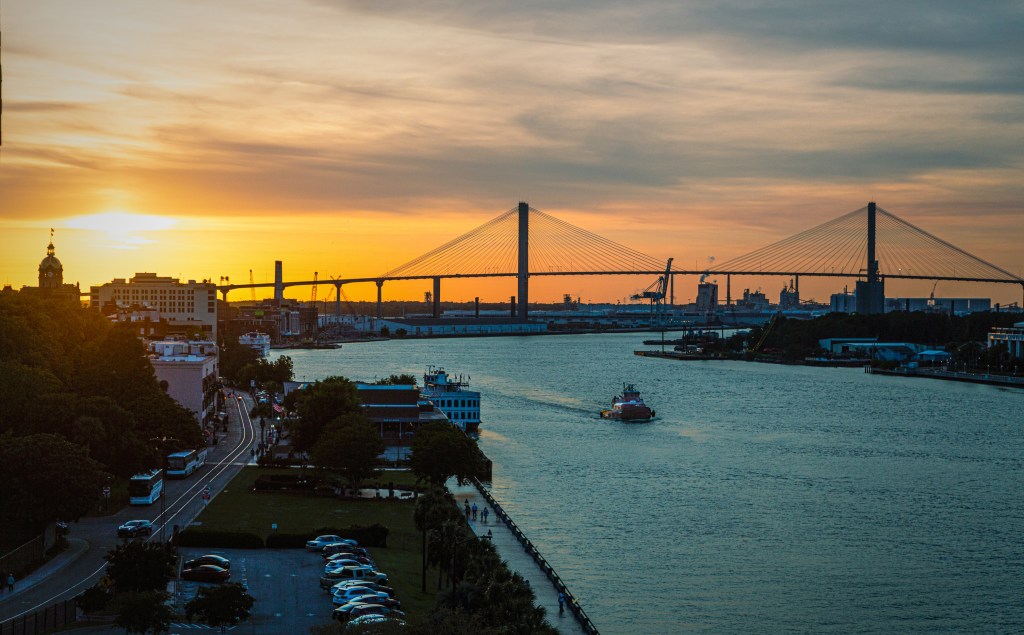 Savannah River at sunset with tugboat and Talmadge Bridge.