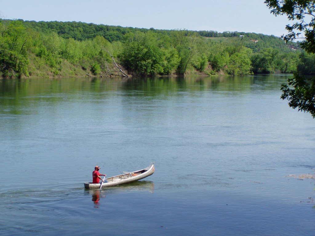 Man canoeing on a river.