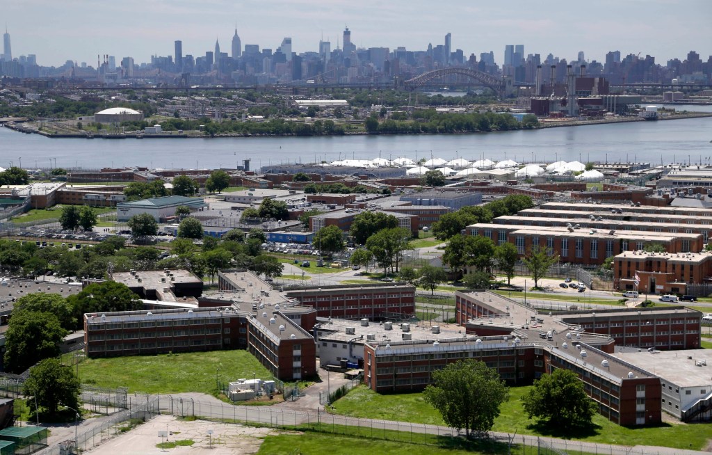 Aerial view of Rikers Island jail complex with the Manhattan skyline in the background.