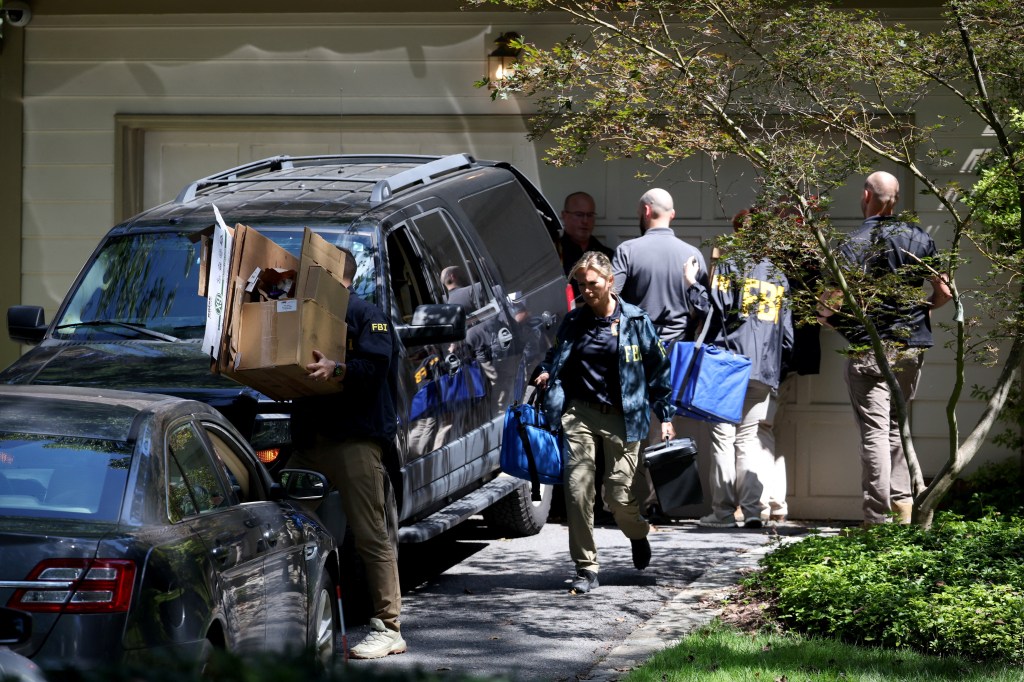 FBI agents removing boxes from John Bolton's home.