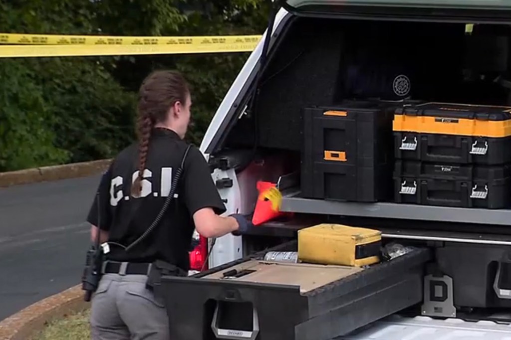 Forensic investigator loading equipment into a truck.