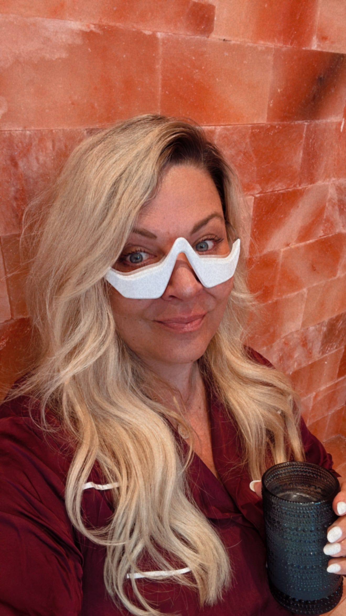 Tracey Halama, CEO of Supergut, wearing red light glasses and drinking her functional coffee.