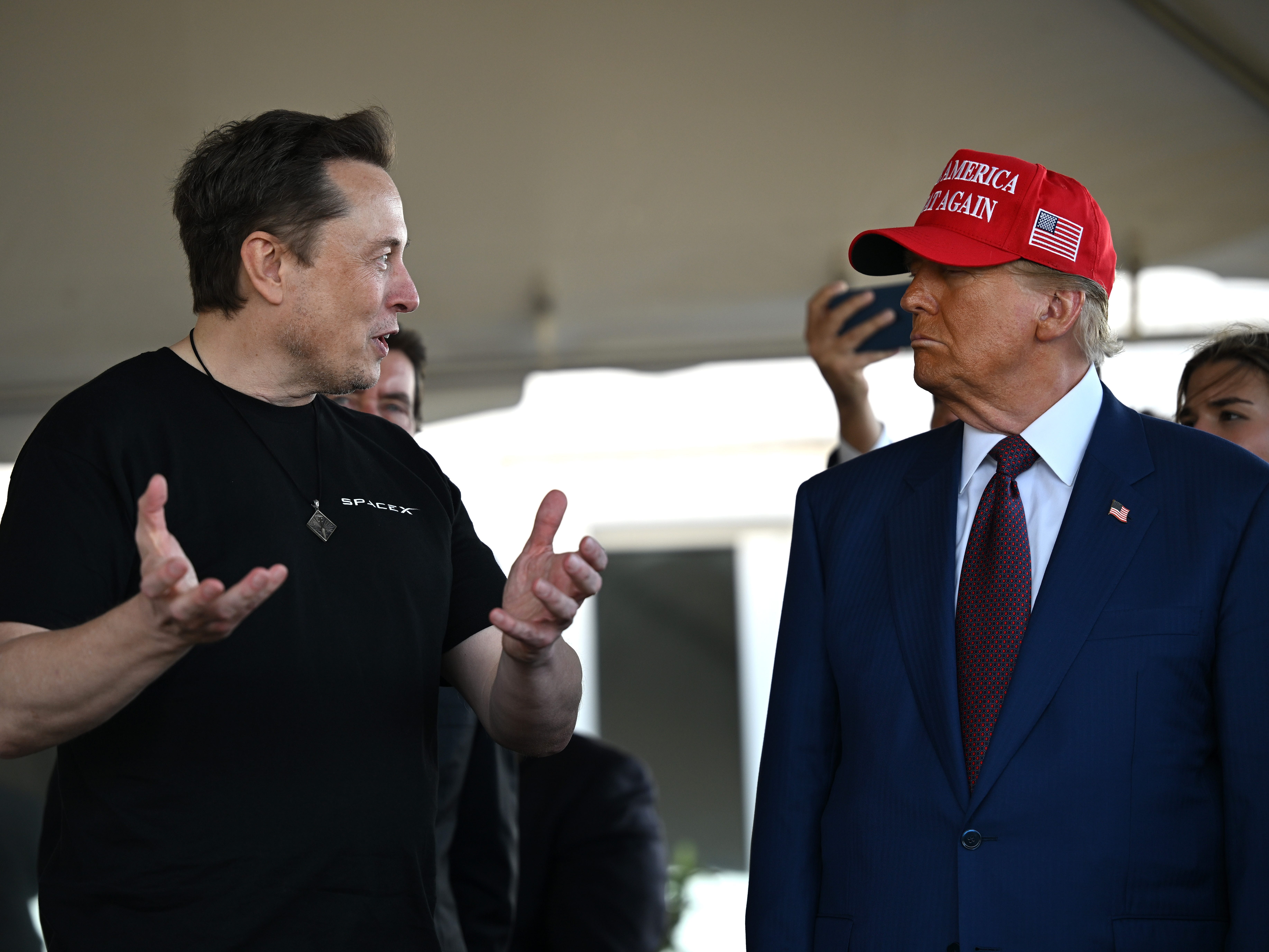 Donald Trump and Elon Musk stand