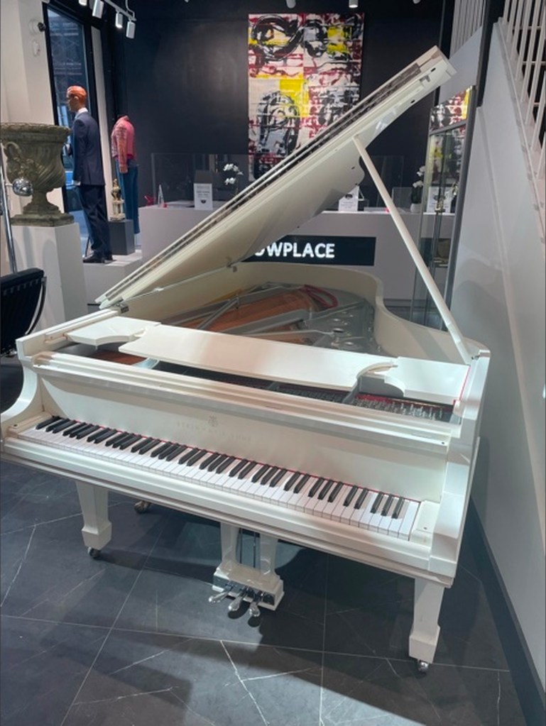 White Steinway grand piano at auction.