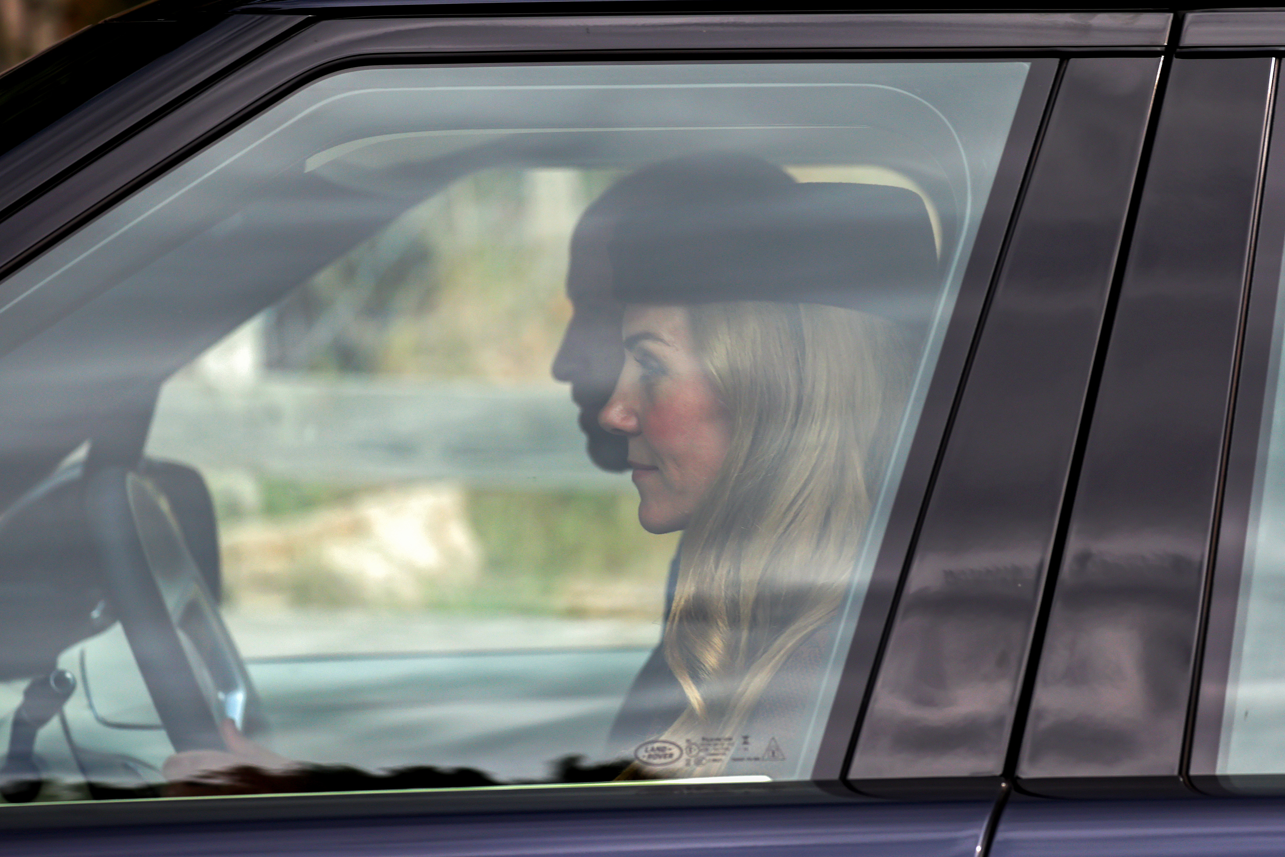 Prince William and Kate Middleton with their three kids in a car.