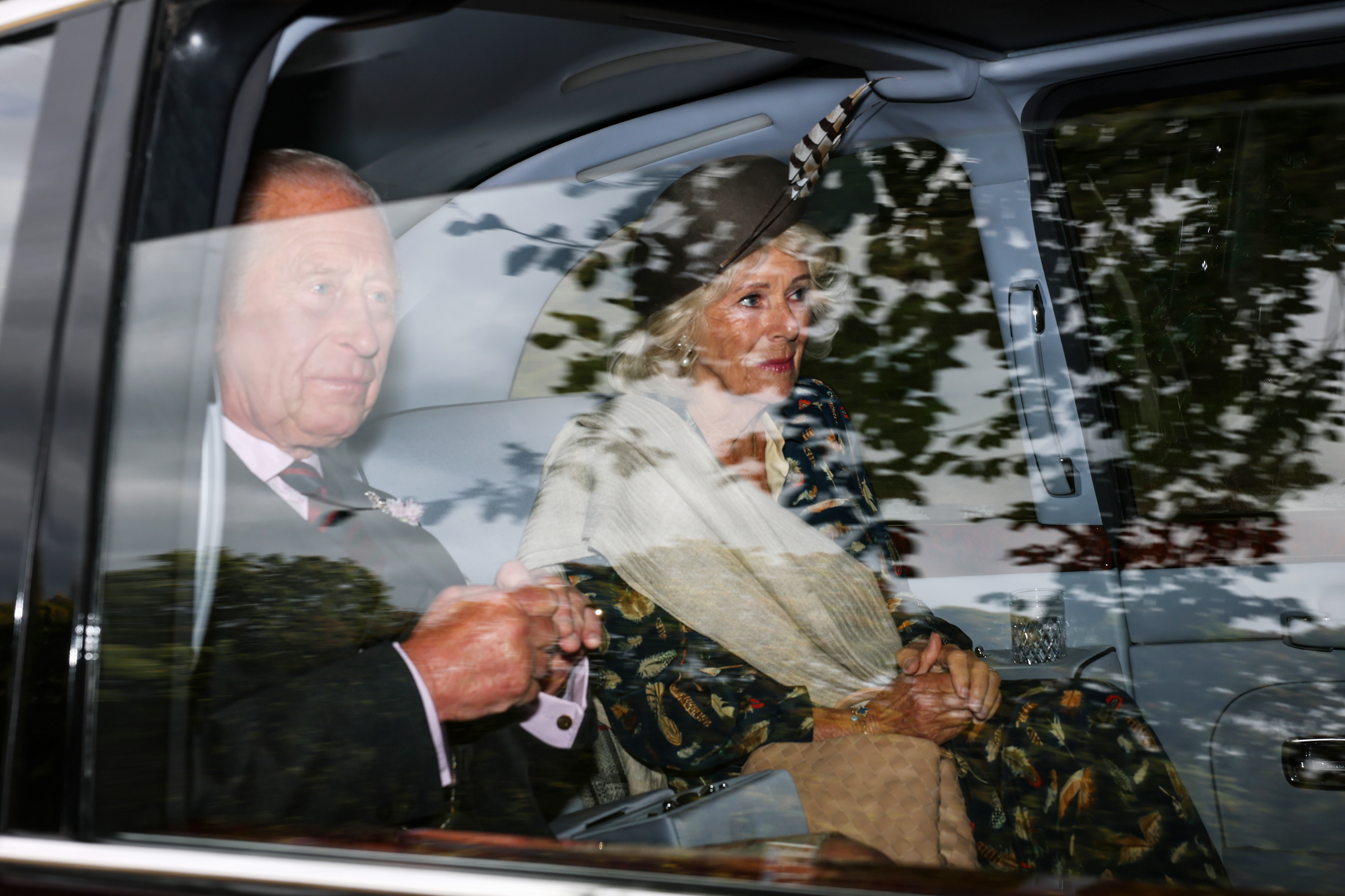 King Charles III and Queen Camilla in a car.