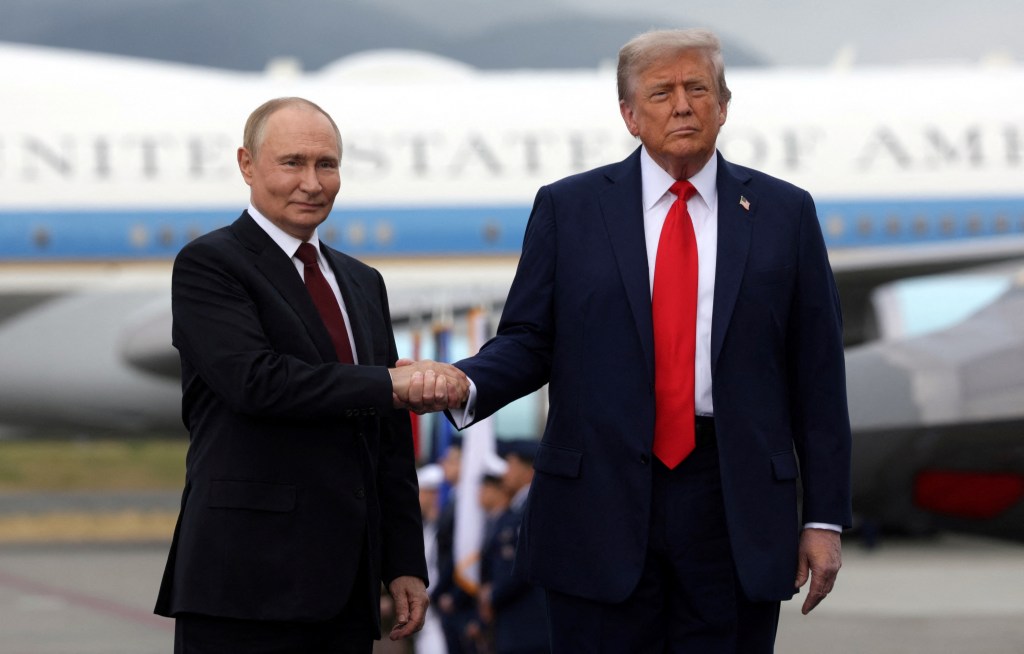 Trump and Putin shaking hands at a summit.