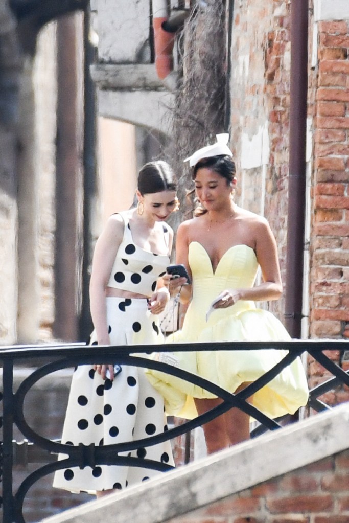 Lily Collins (left) and Ashley Park share a laugh while filming  Season 5 of “Emily in Paris” in Venice, Italy.