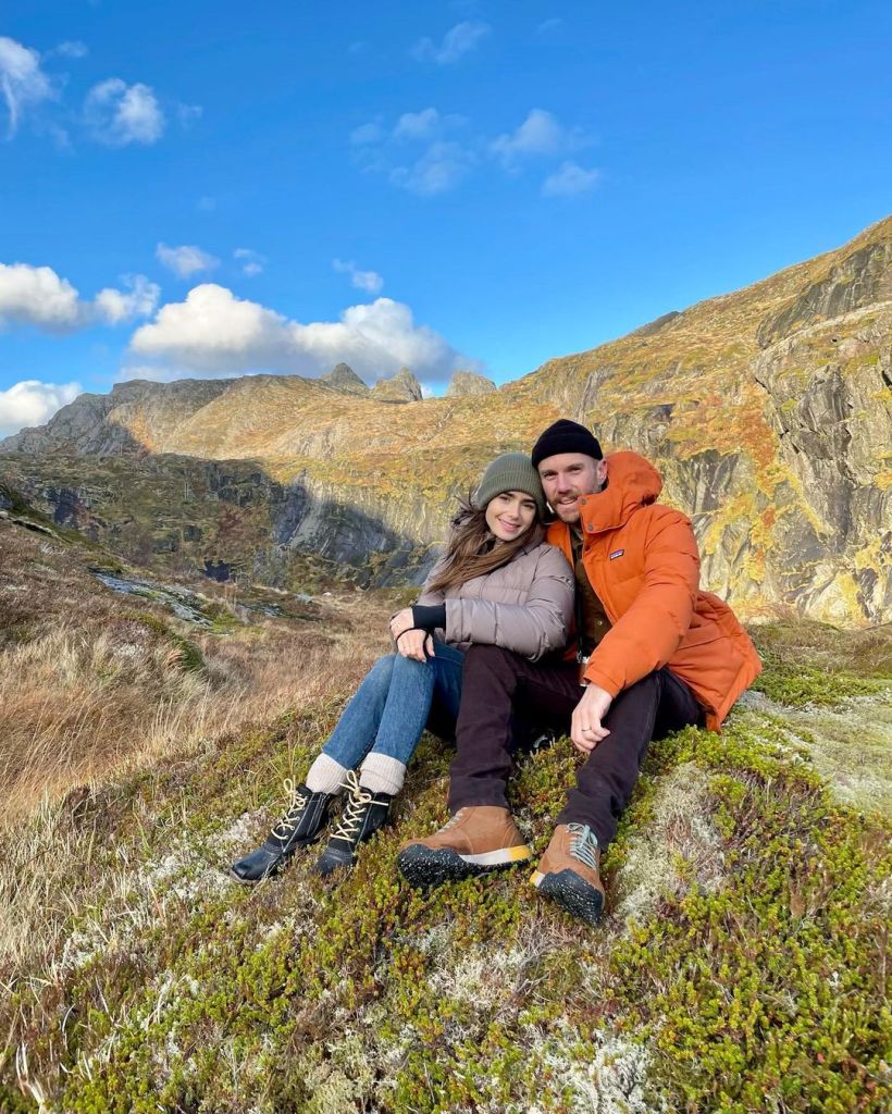 Lily Collins and husband Charlie McDowell sitting down during a hike.