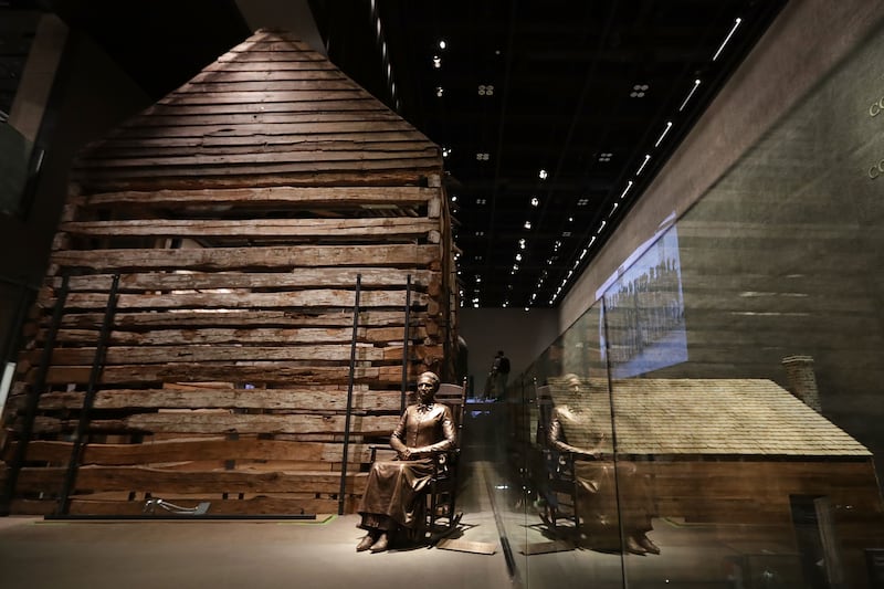 A statue of Colorado pioneer and former slave Clara Brown is on display next to a preserved slave cabin at the Smithsonian's National Museum of African American History and Culture.