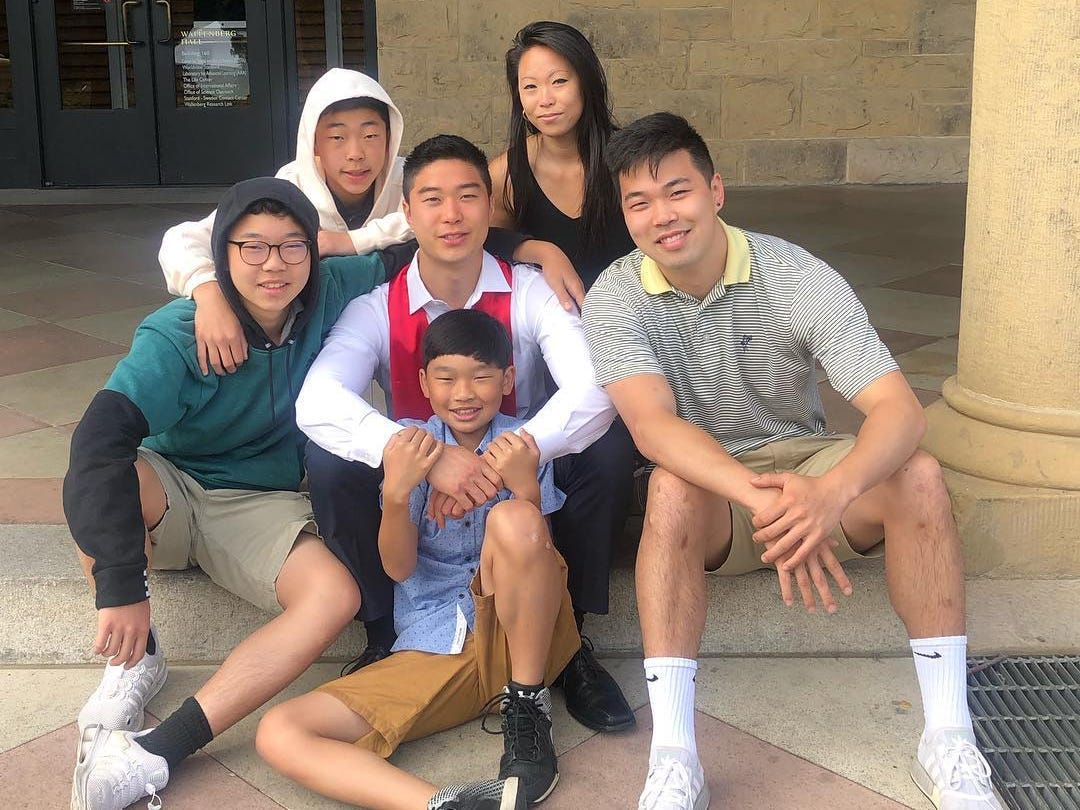 Six siblings are sitting on a step.