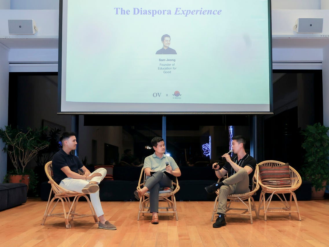 Tyger Cho is talking about the Diaspora Experience onstage with two others.