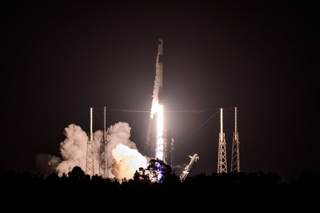 SpaceX rocket launching at night.