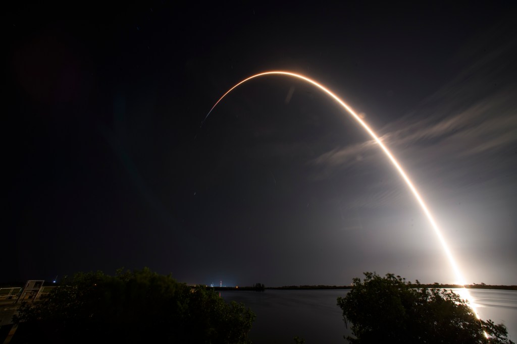 SpaceX rocket launching at night.