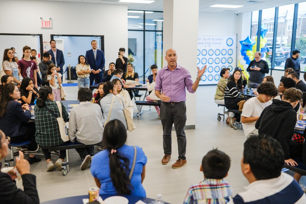 A man addresses a crowd of students, parents, faculty, and staff at the opening of MESA South Brooklyn Charter High School.