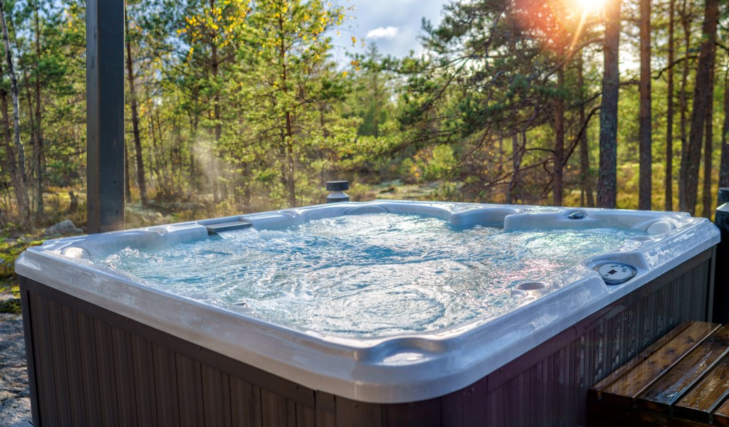 Hot tub in a forest at sunset.