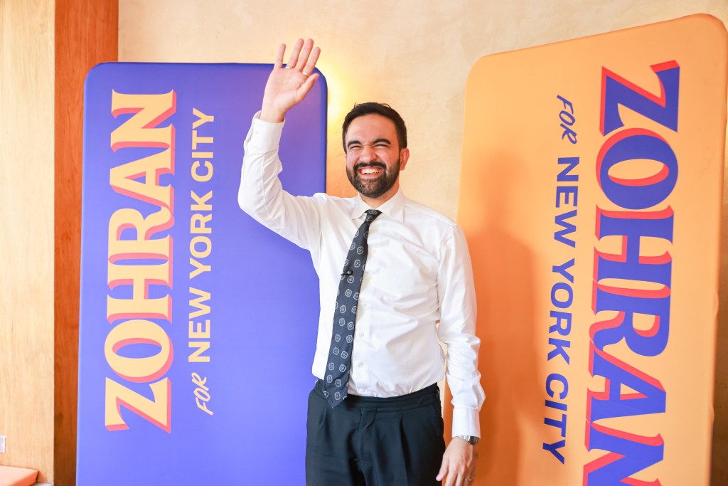 NYC mayoral candidate Zohran Mamdani waving to supporters.