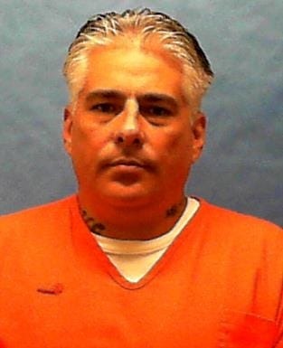 Mugshot of a man in an orange jumpsuit.
