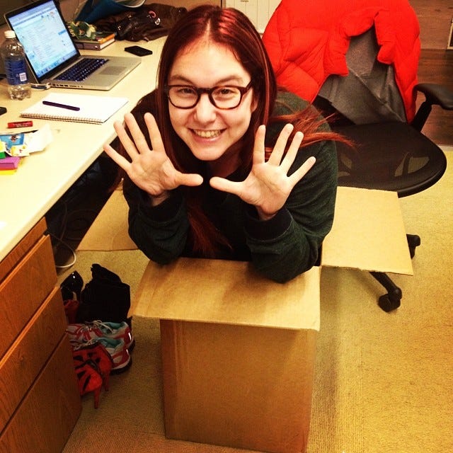 woman with glassess popping out of a cardboard box