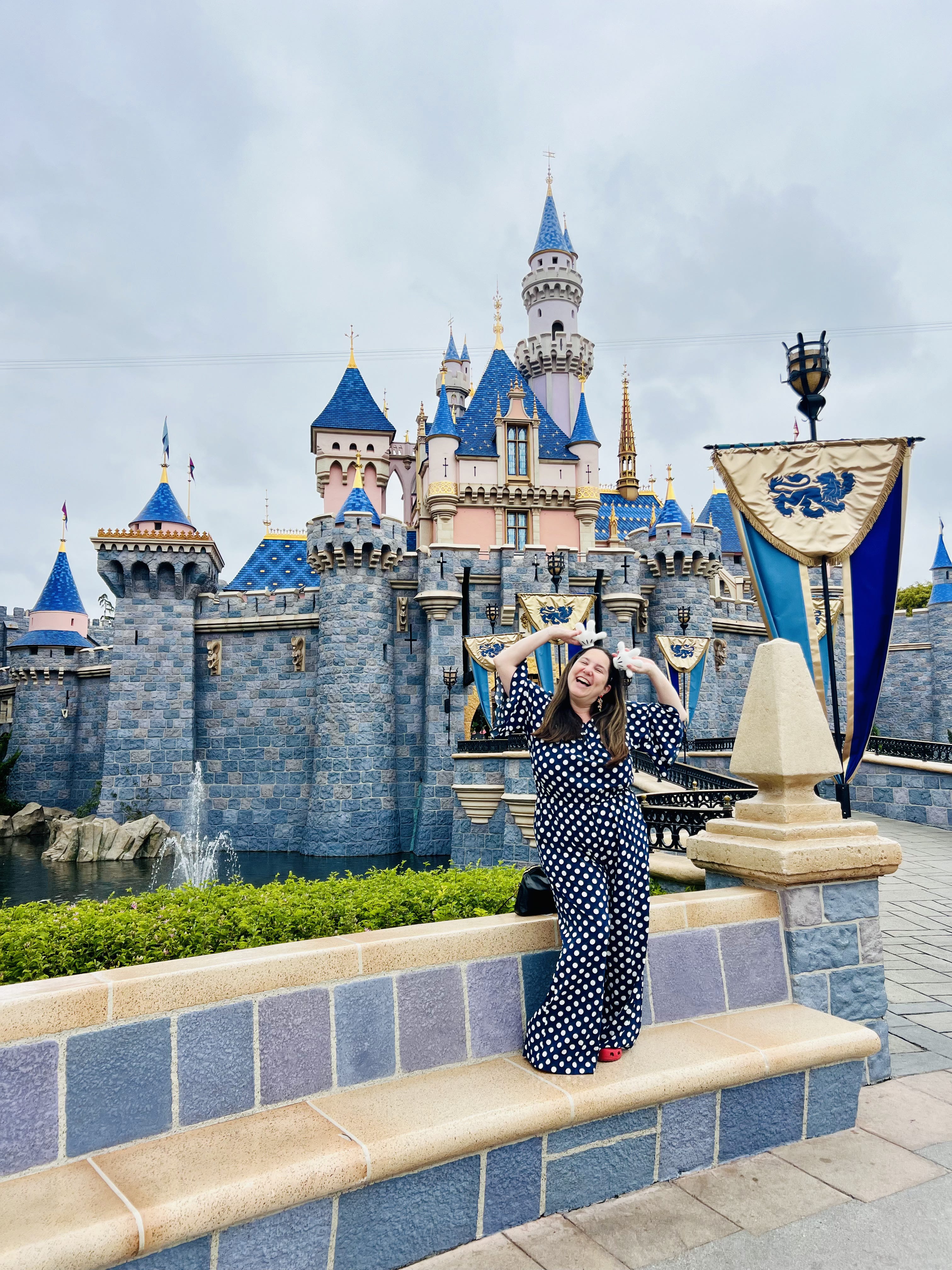 woman standing in front of castle in Disneyland