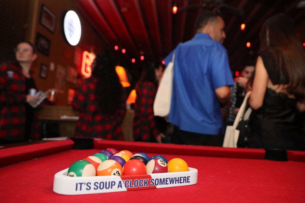 Pool balls in a rack on a pool table at a bar.
