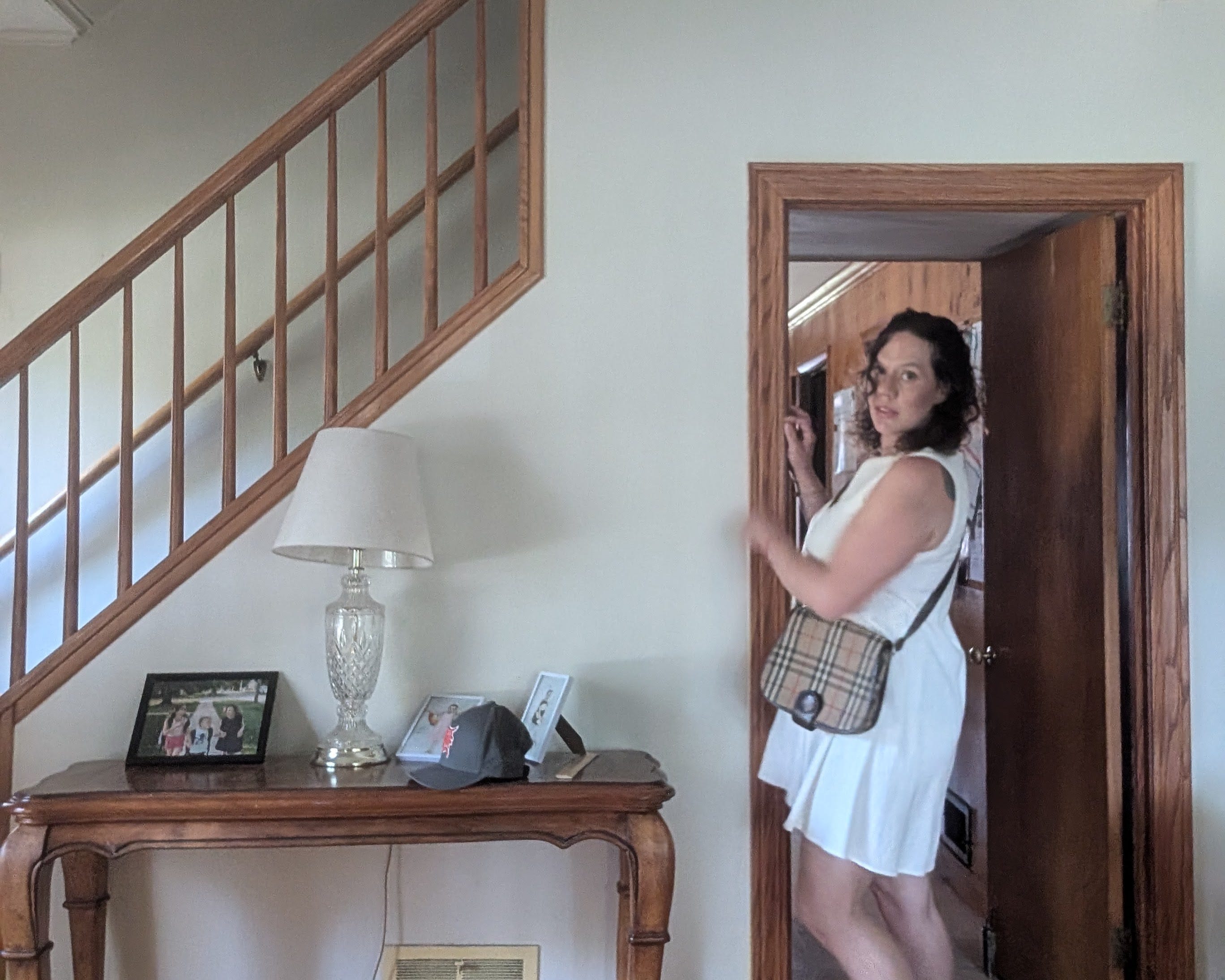 woman in white dress standing next to a staircase