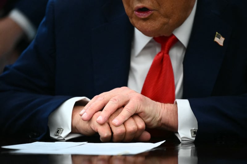 A detail view of US President Donald Trump's hands as he speaks to the press before signing an executive order that aims to end cashless bail, in the Oval Office of the White House in Washington, DC on August 25, 2025.