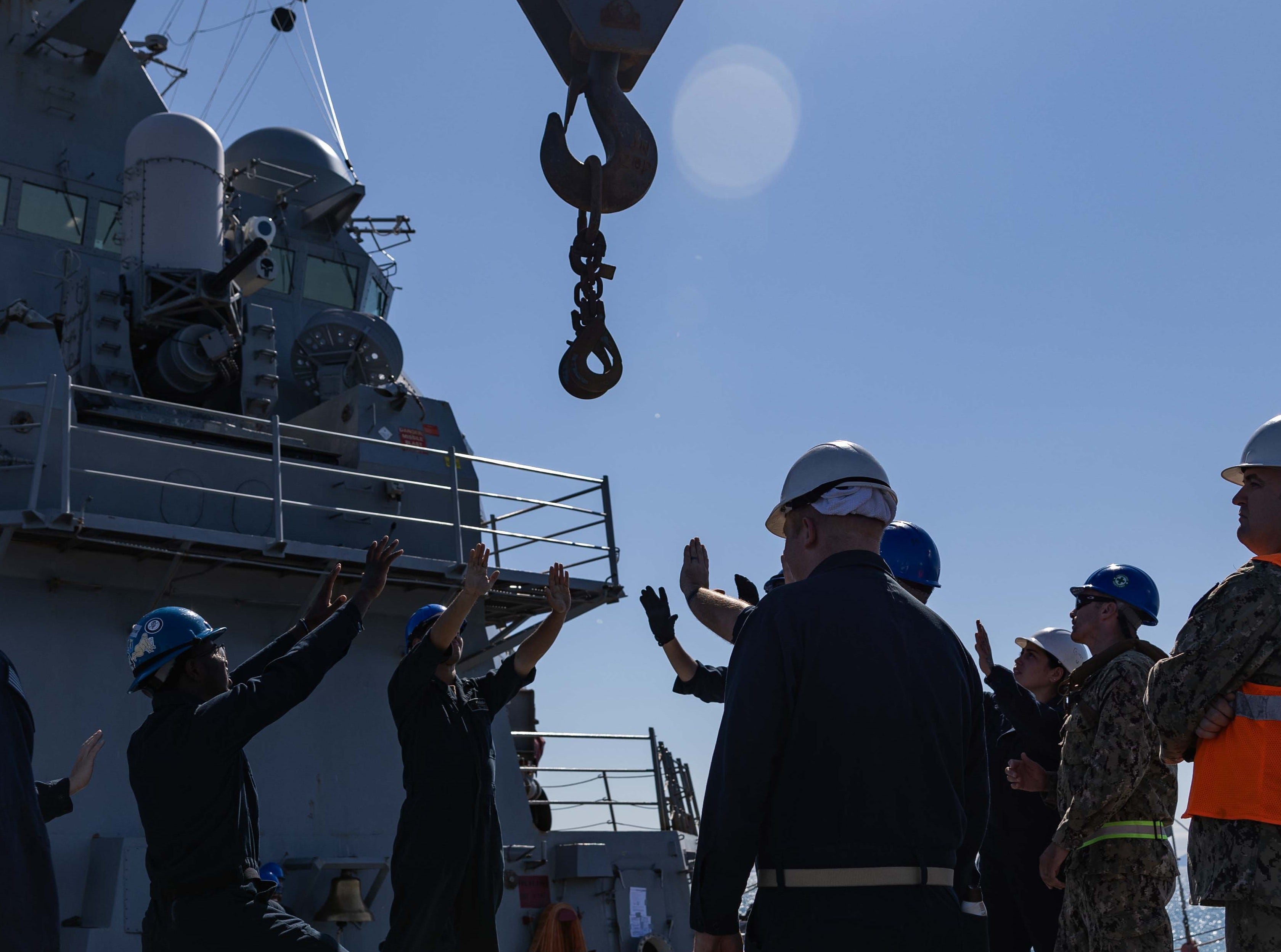 Sailors aboard the Arleigh Burke-class guided-missile destroyer USS Higgins (DDG 76) simulate loading ammunition from a barge during Noble Prime 25-3 in the Cleveland Bay, Australia, July 28.