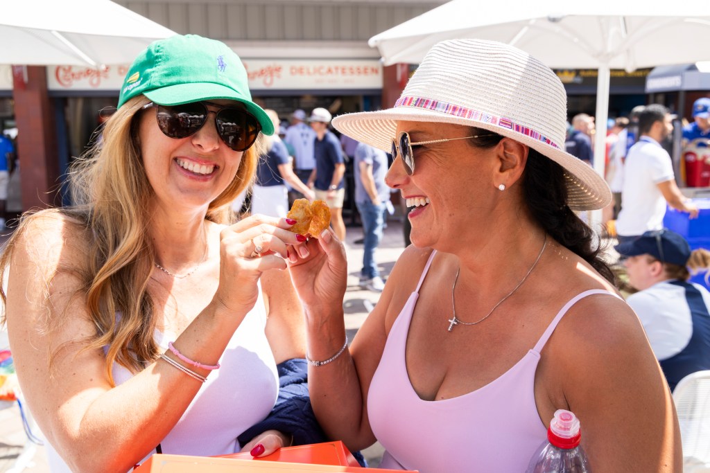 Two women at the U.S. Open share a chicken nugget.