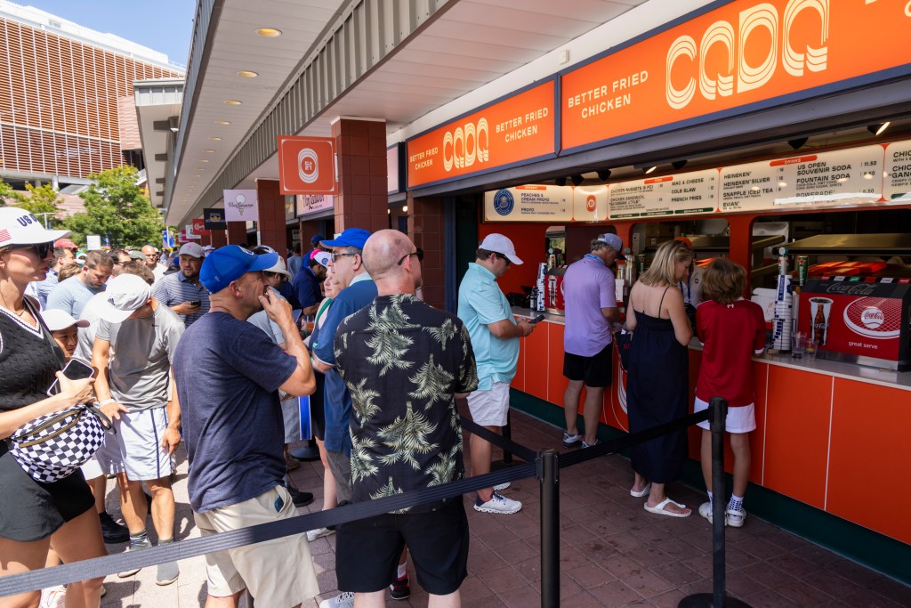 US Open tennis spectators line up at a Coqodaq food stand.