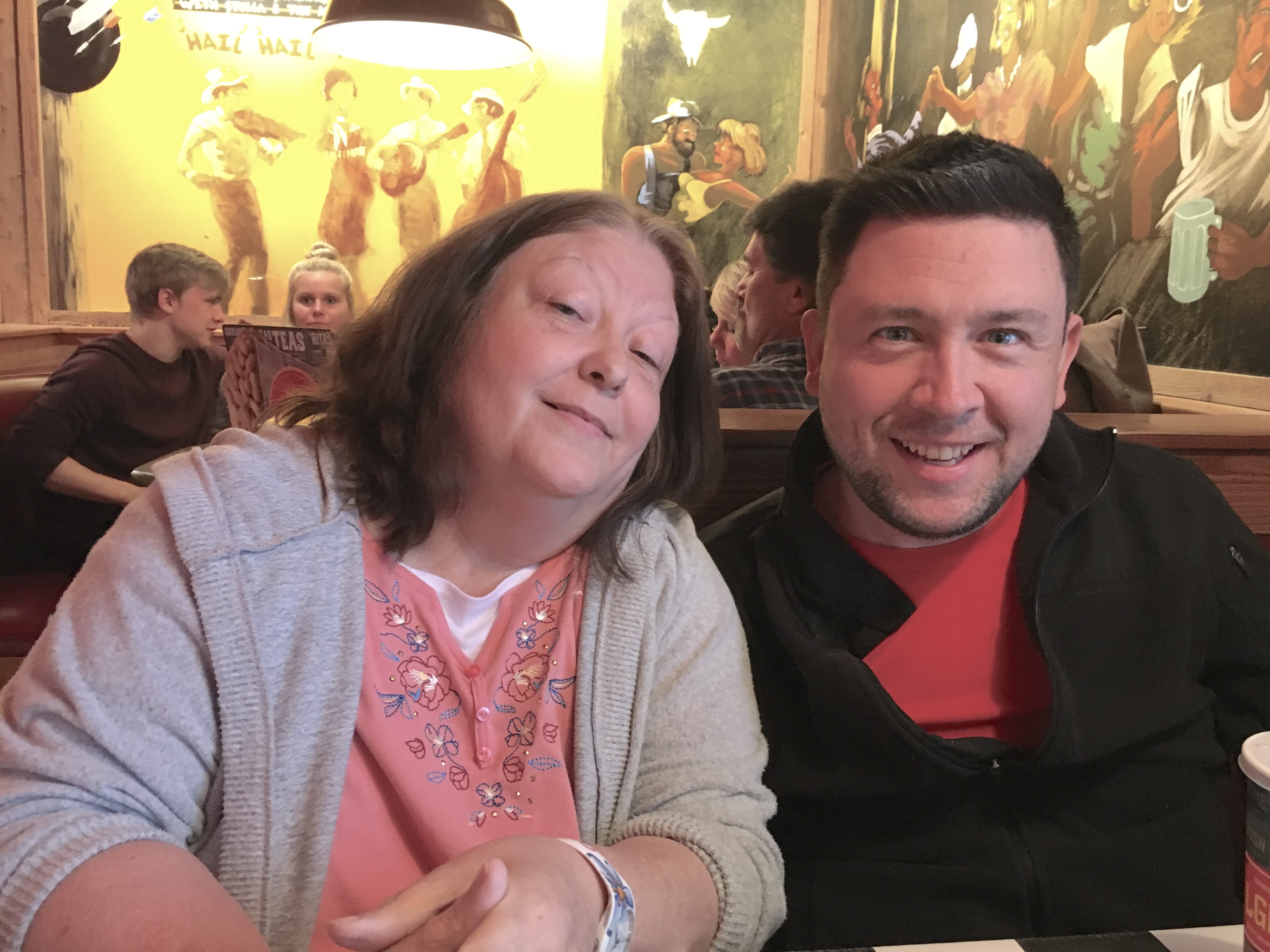 The author poses with his mother in a restaurant.