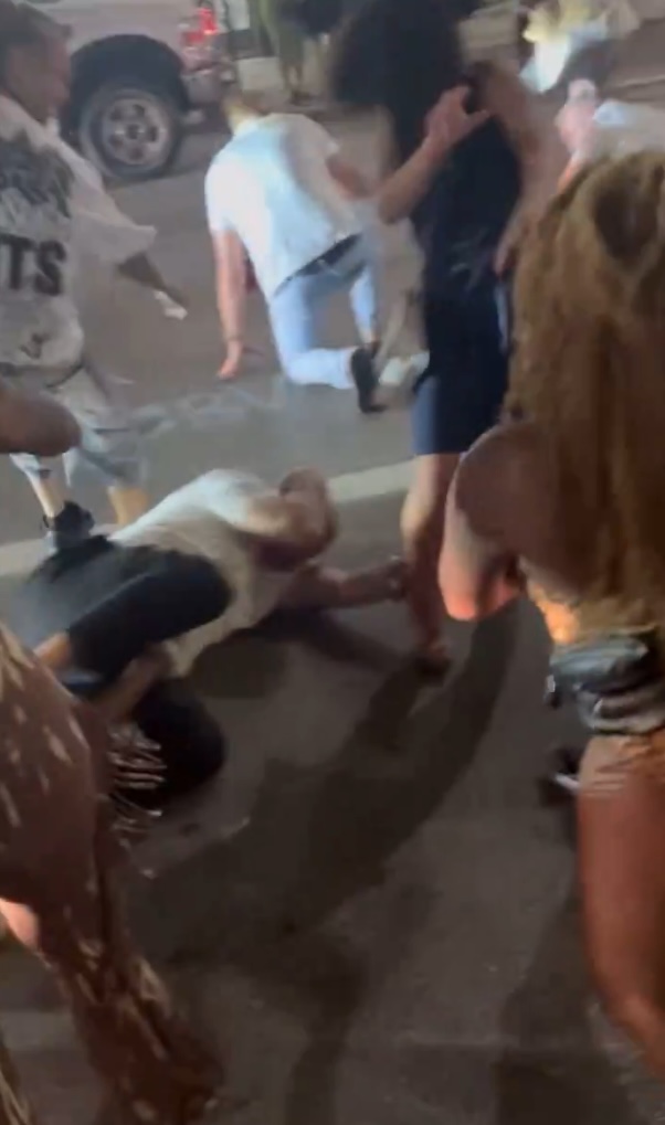 A man on the ground surrounded by people.