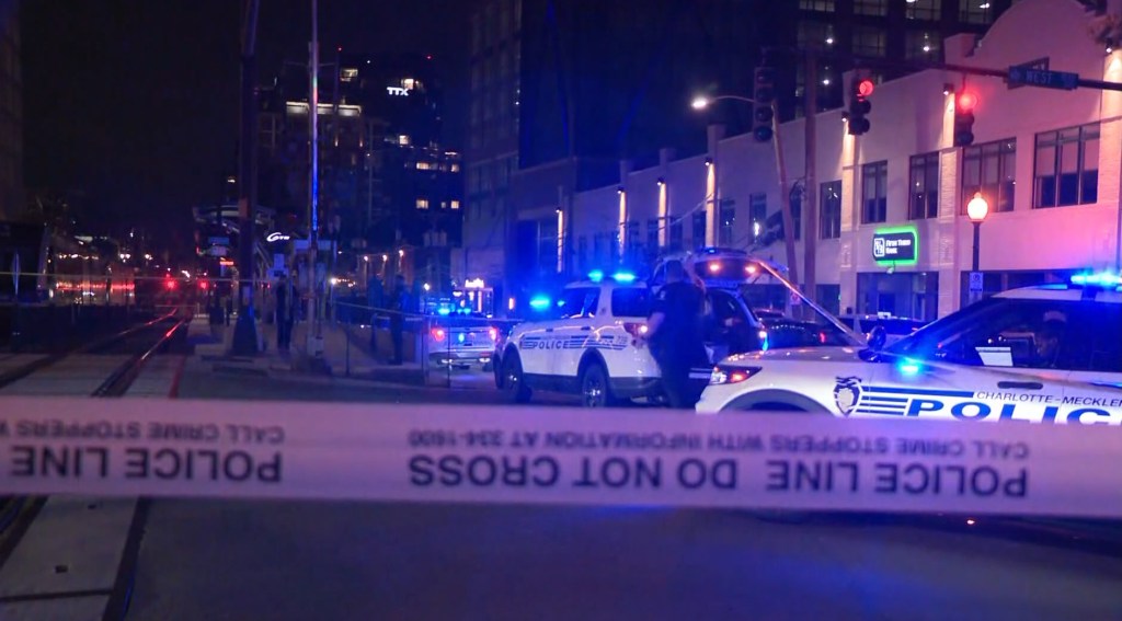 Crime scene at night with police cars and crime scene tape.