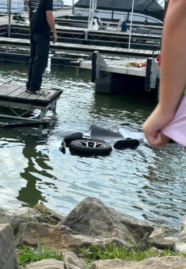 Submerged vehicle parts near a dock.