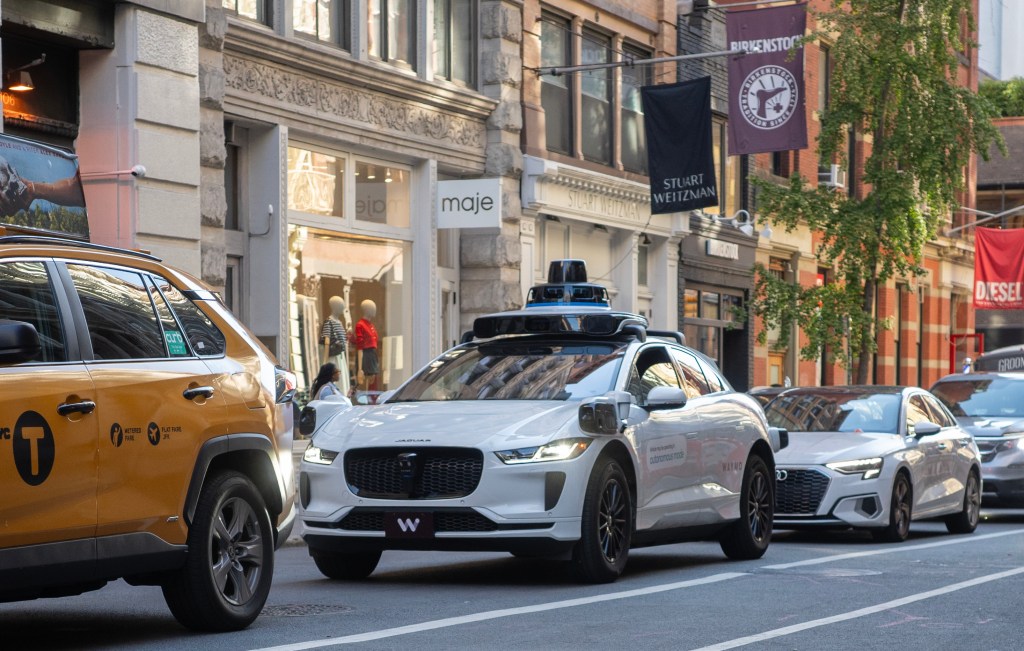A Waymo self-driving car in city traffic.