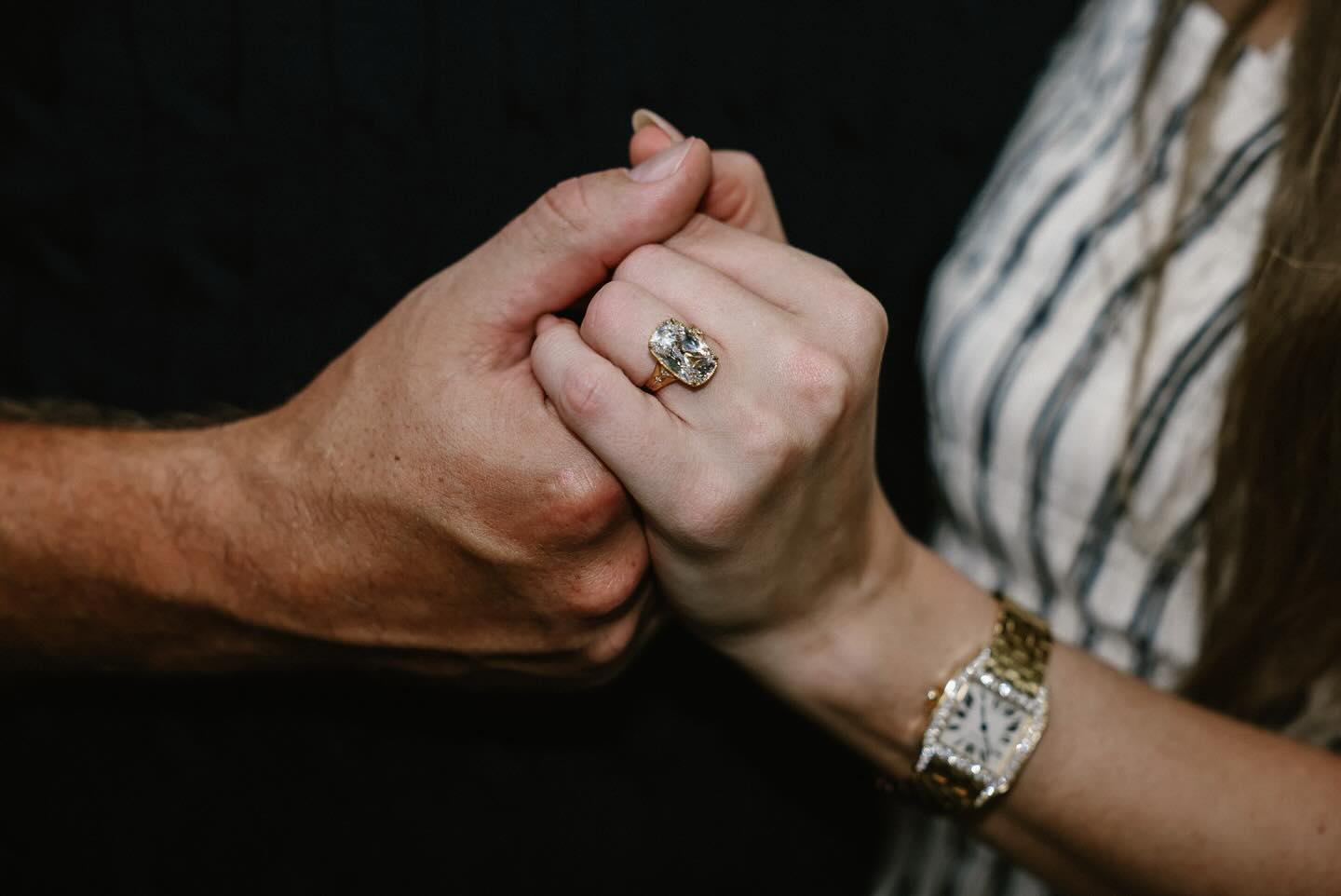 Taylor Swift and Travis Kelce's hands with an engagement ring. 