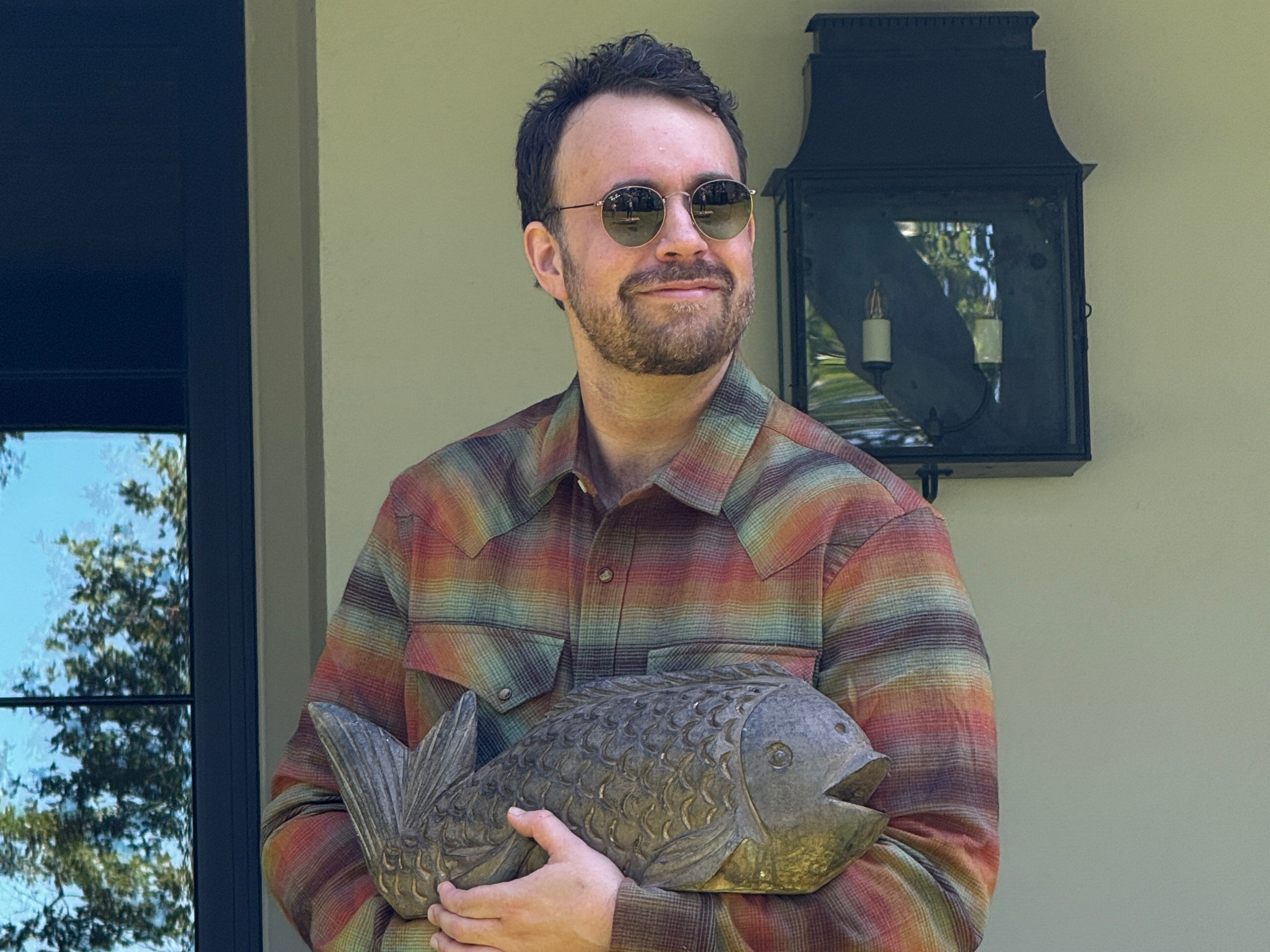 Ben Goodwin holding fish statue