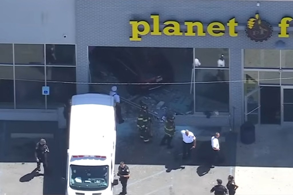 Car crashed into Planet Fitness; emergency responders on scene.