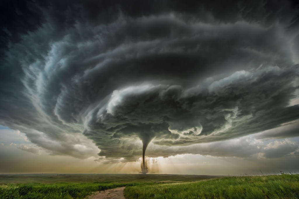 Large tornado over a grassy field.