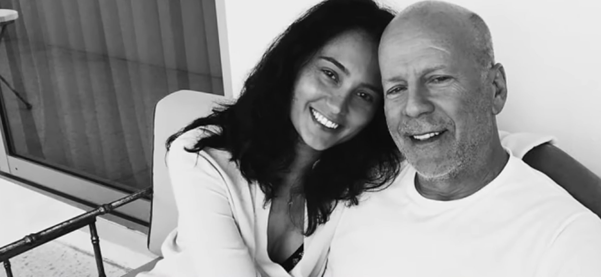 A black-and-white photo of Bruce Willis and Emma Heming
