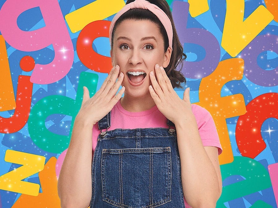 Ms. Rachel with her hands on her cheeks, wearing a pink headbank and overalls, surrounded by animated numbers and letters.