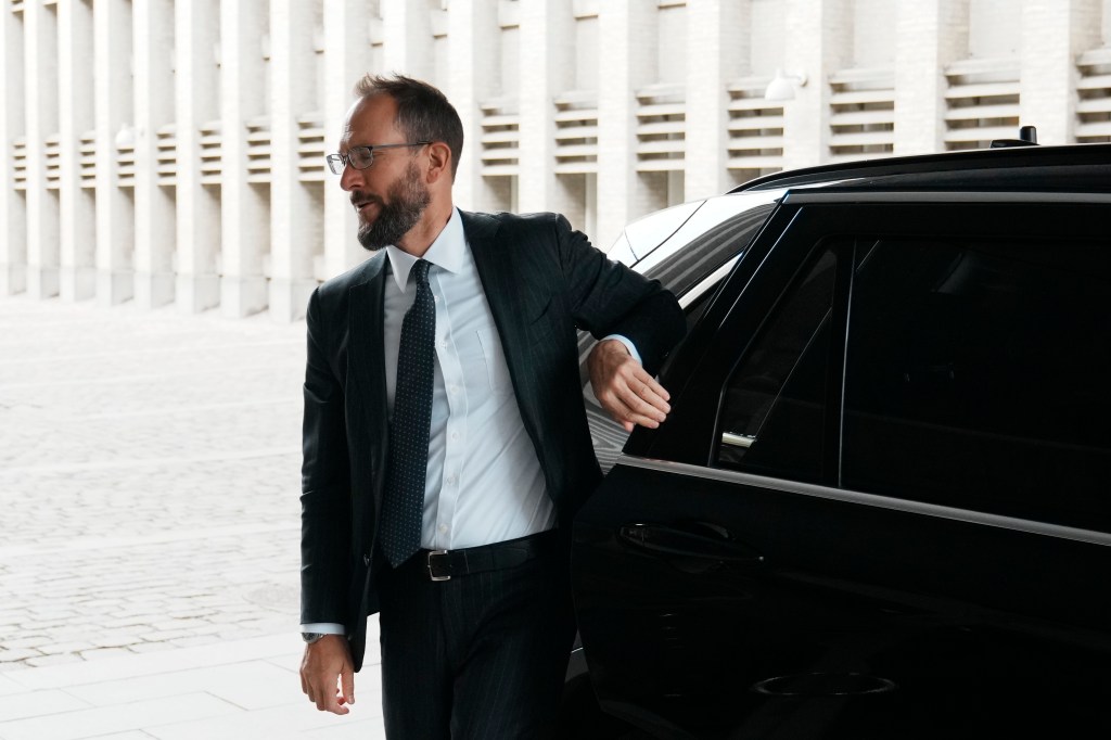 Man in suit exiting a car.